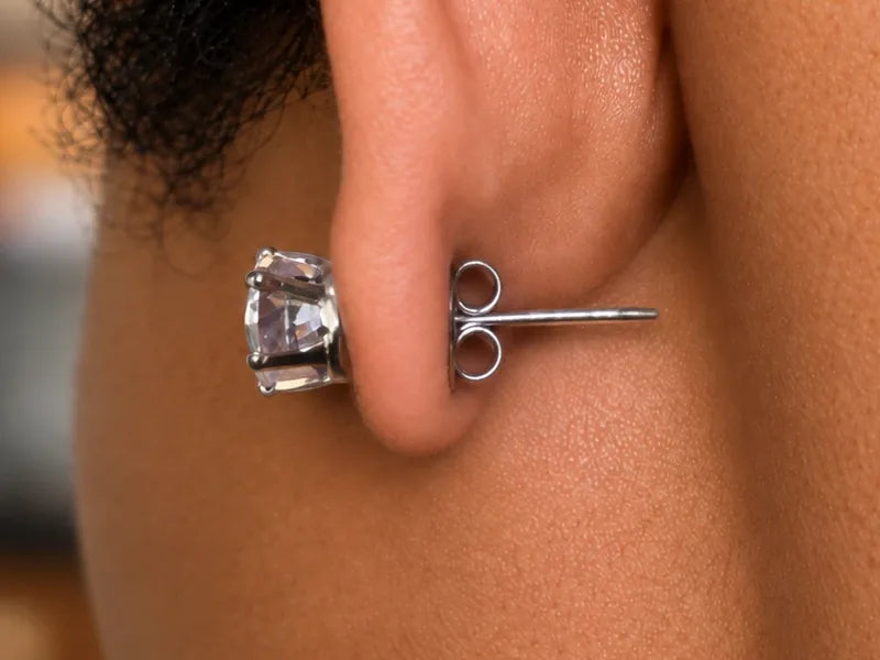 Close-up of the back of an ear wearing SnapMags, with a slim magnetic stem and a small back behind the earlobe.